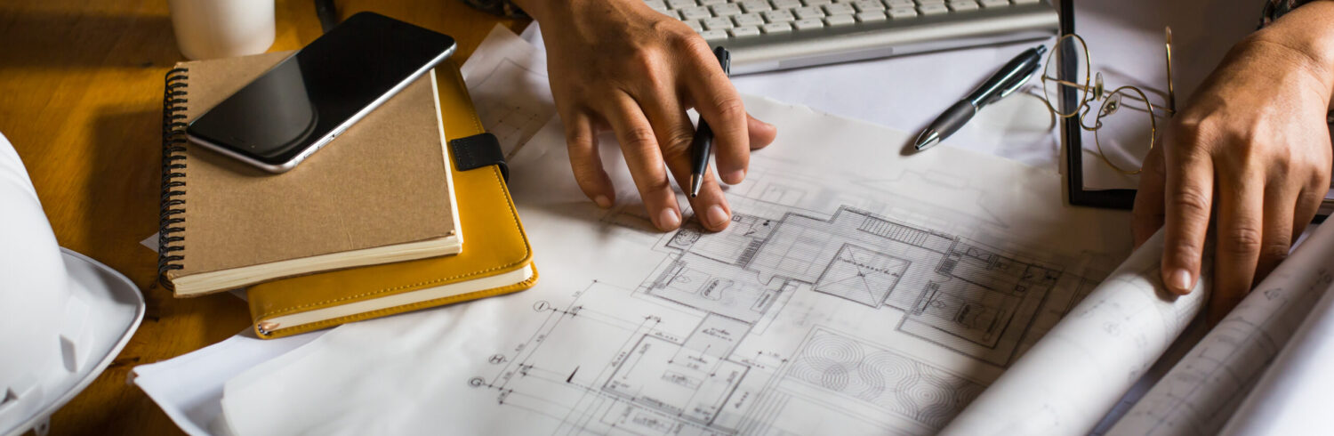 Creative architect projecting on the big drawings in the dark loft office or cafe with dark and retro style.